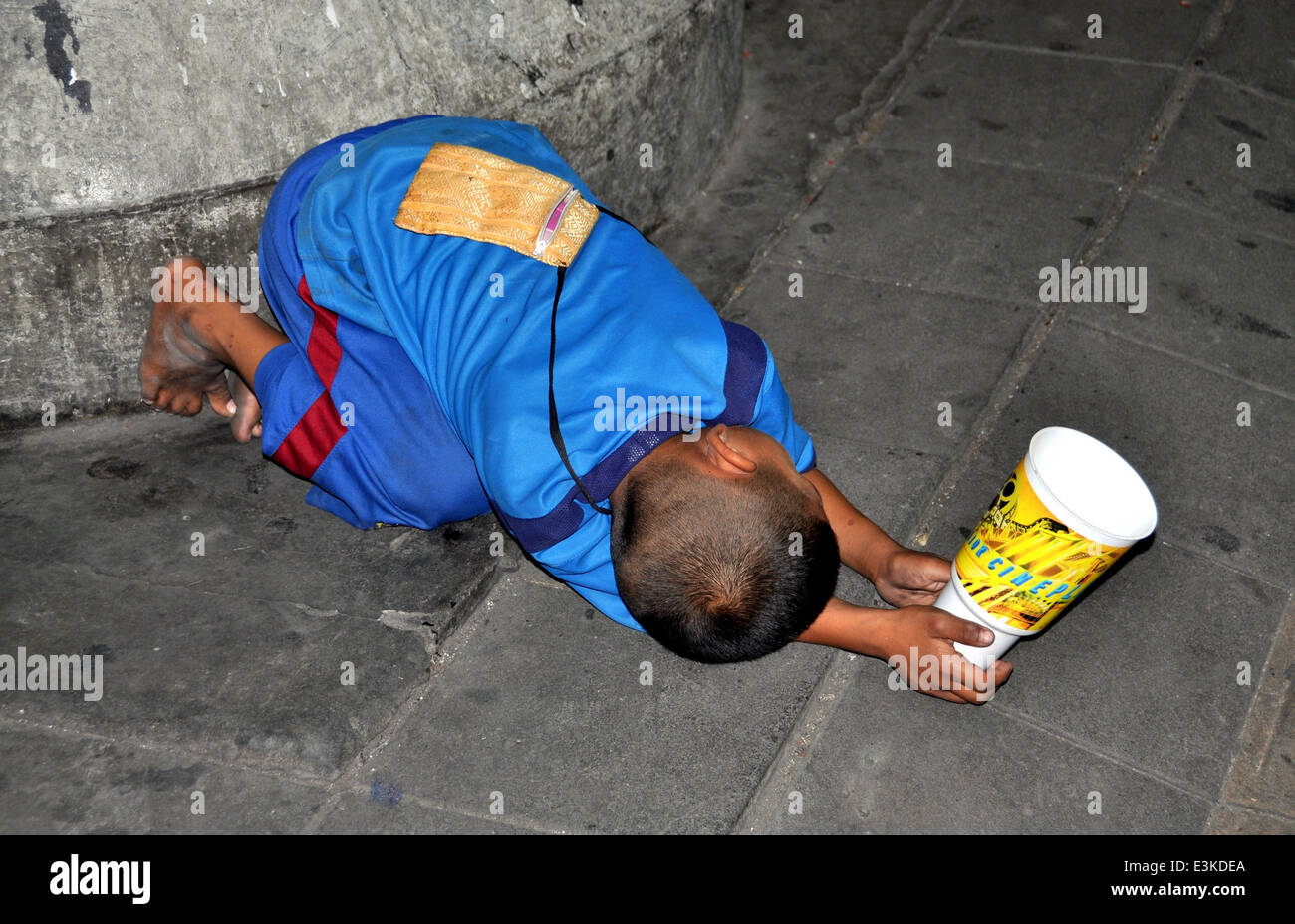 Bangkok, Thailand: Street Urchin hält einen Pappbecher betteln um Geld Stockfoto