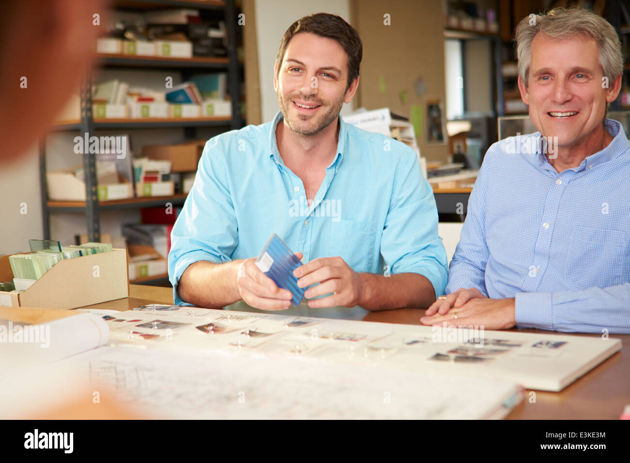 Drei Architekten an Tisch treffen Stockfoto