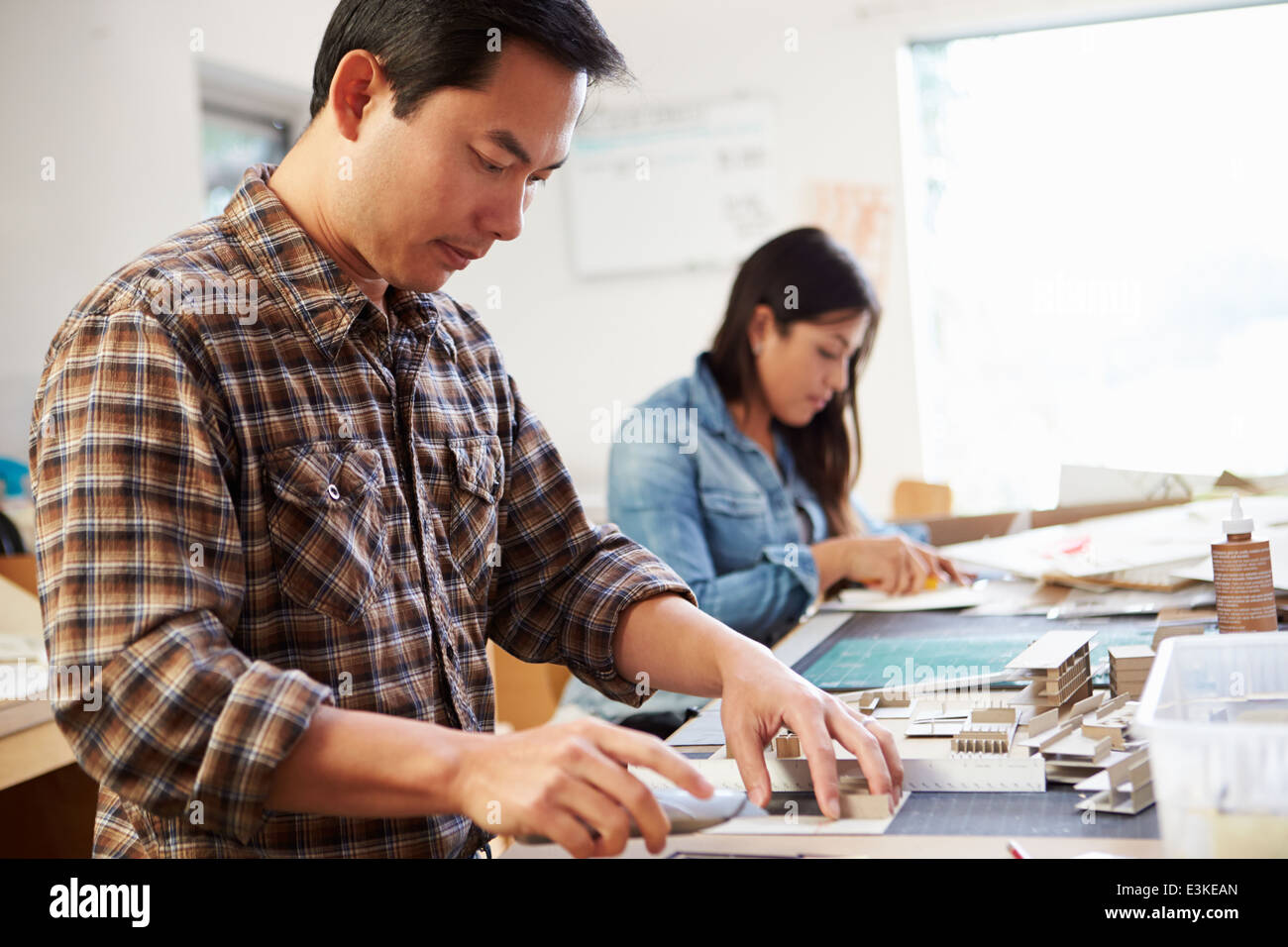 Männliche Architekten arbeiten am Modell im Büro Stockfoto