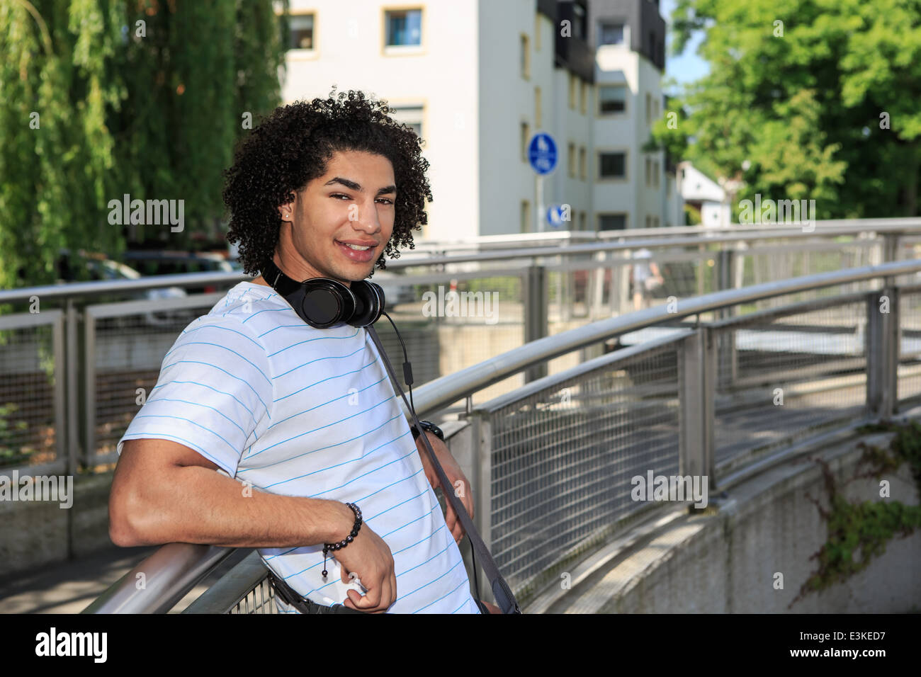Porträt des jungen männlichen Studenten mit einem Kopfhörer in der Stadt Stockfoto