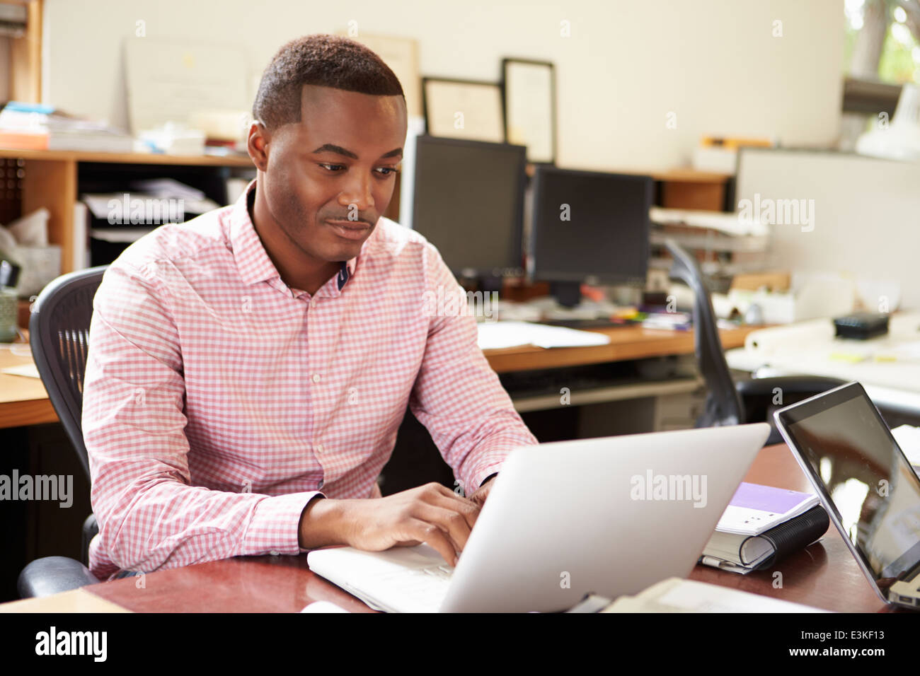 Männliche Architekten arbeiten am Schreibtisch auf Laptop Stockfoto