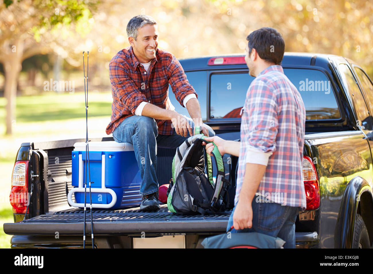 Zwei Männer Auspacken Pick Up Truck im Camping Urlaub Stockfoto