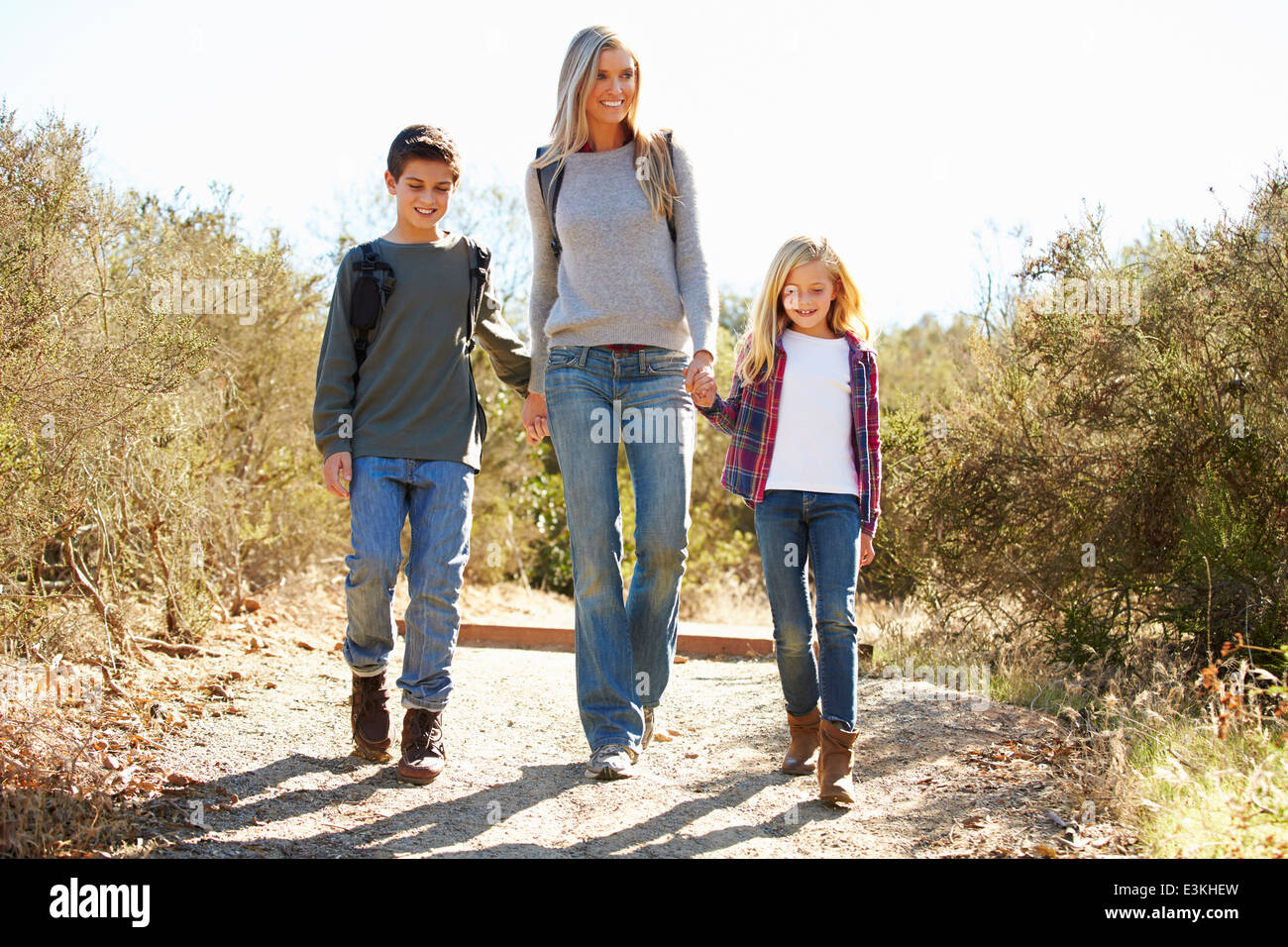 Mutter und Kinder Wandern im Land tragen Rucksäcke Stockfoto