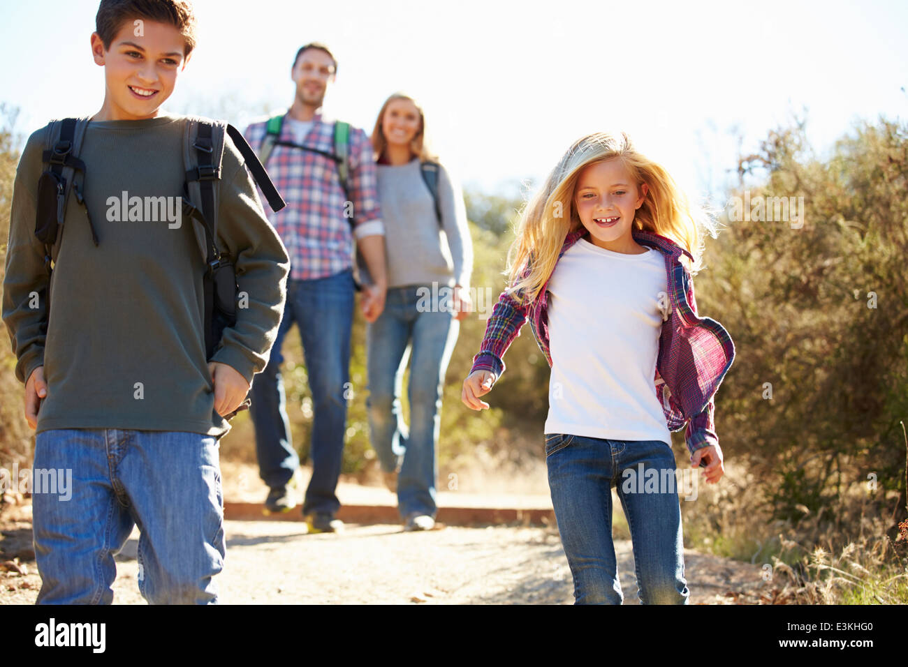 Mutter und Kinder Wandern im Land tragen Rucksäcke Stockfoto