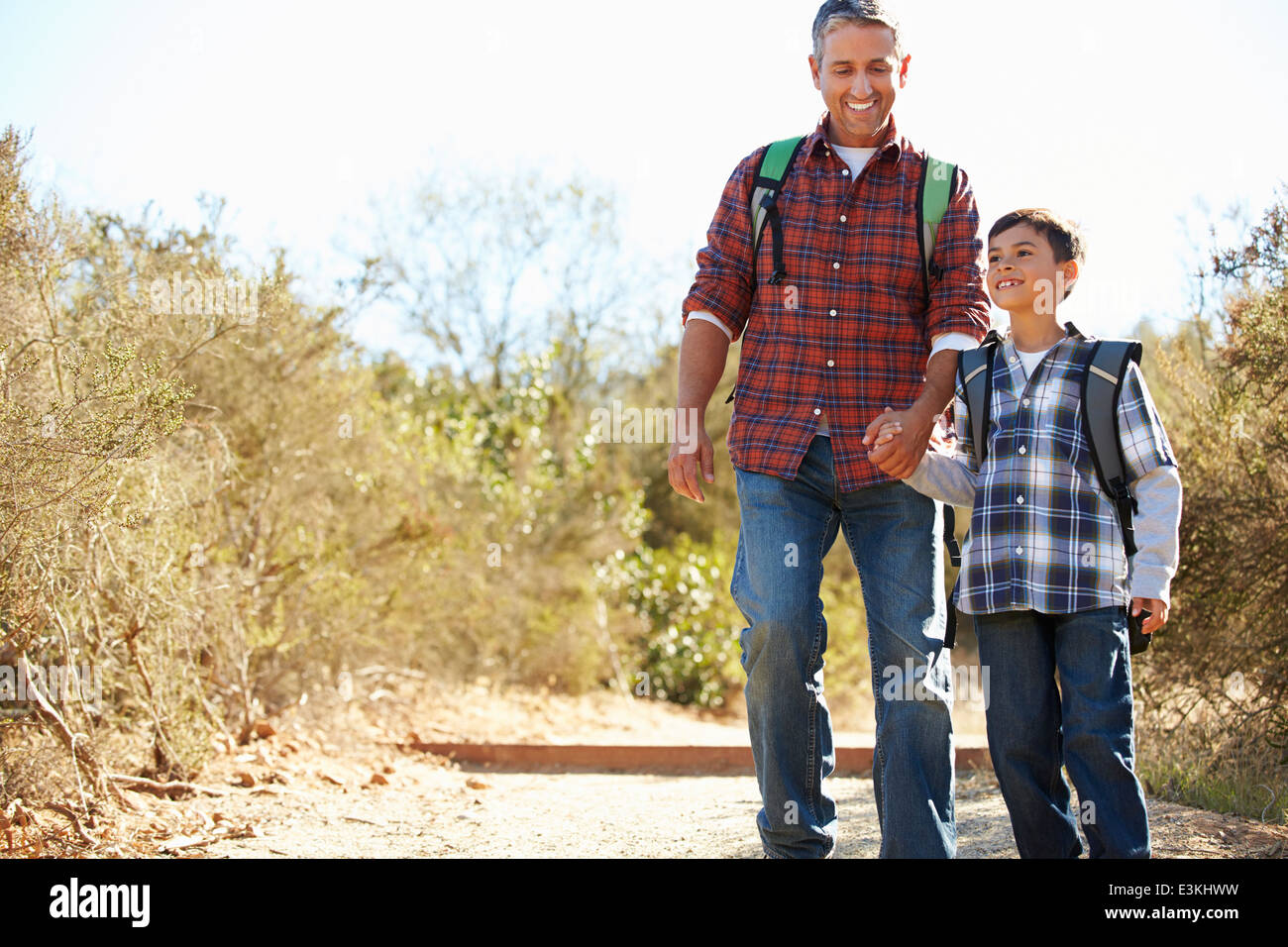 Vater und Sohn wandern im Land tragen Rucksäcke Stockfoto