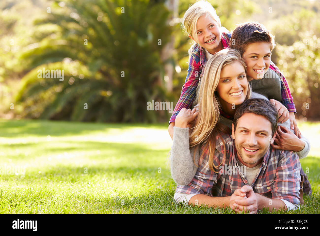 Porträt der Familie liegen auf dem Rasen In Landschaft Stockfoto