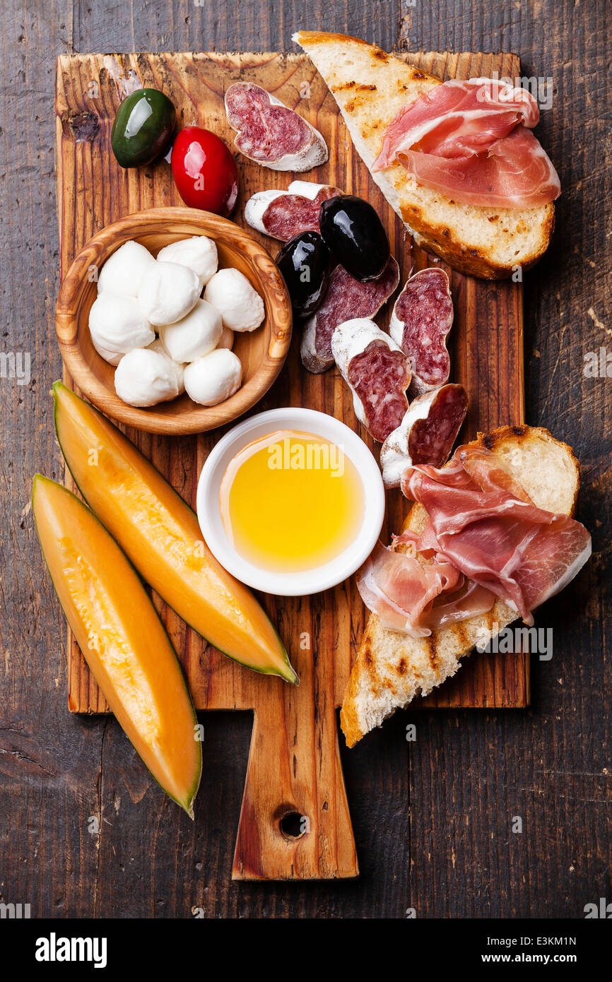 Schinken, Scheiben Melone Melone, Mozzarella-Käse und Oliven auf Schneidebrett Stockfoto