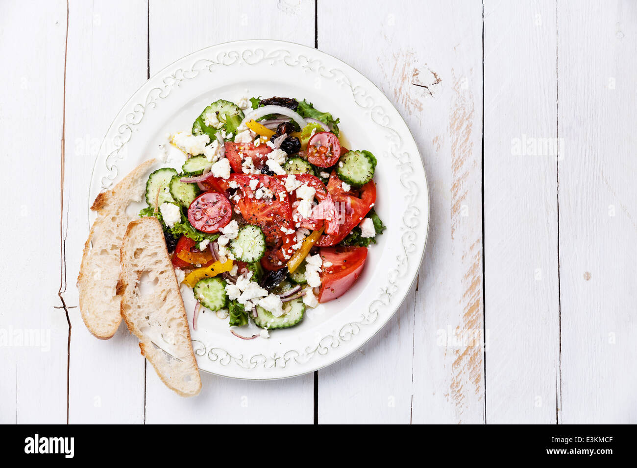 Griechischer Salat mit Fetakäse und sonnengetrocknete Oliven auf weißem Holz Hintergrund Stockfoto