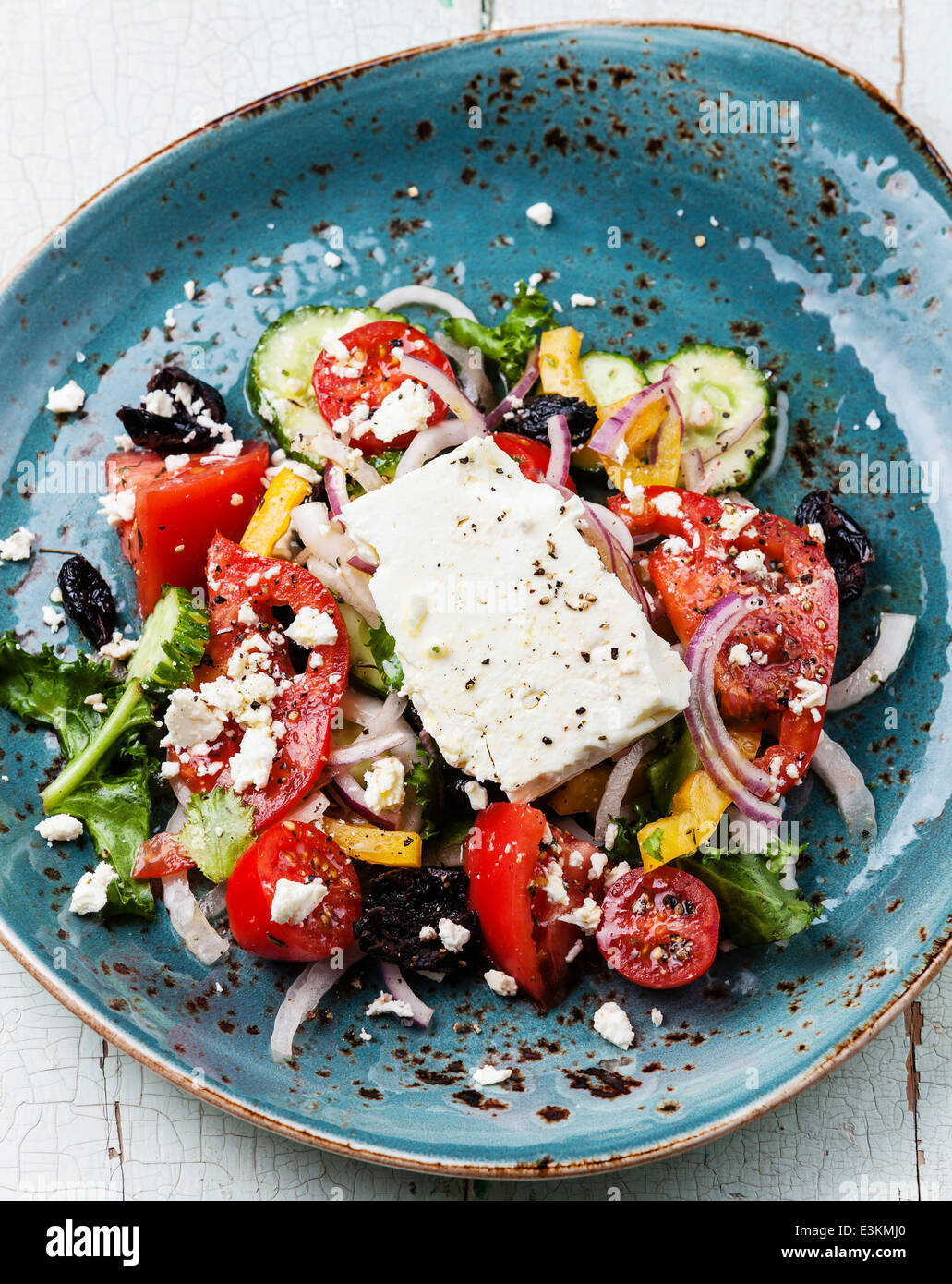 Griechischer Salat mit Fetakäse und sonnengetrocknete Oliven auf blauem Hintergrund Stockfoto