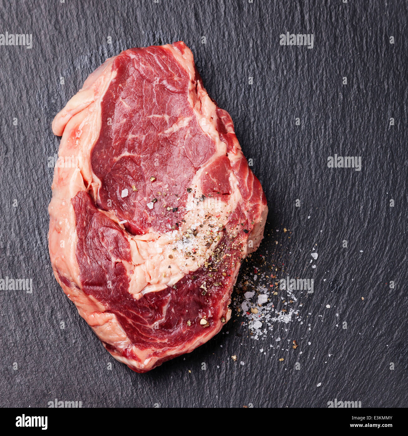 Rohes Frischfleisch mit Gewürzen auf dunklem Hintergrund Stockfoto