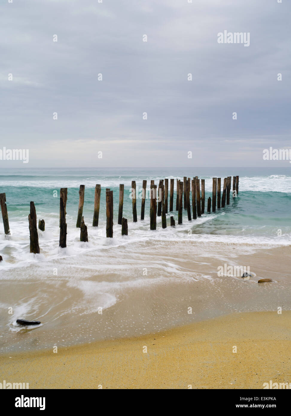 Blick auf die verlassenen Pier auf der St. Clair Strand, mit weißen Insel in der Ferne; Dunedin, Otago, Neuseeland Stockfoto