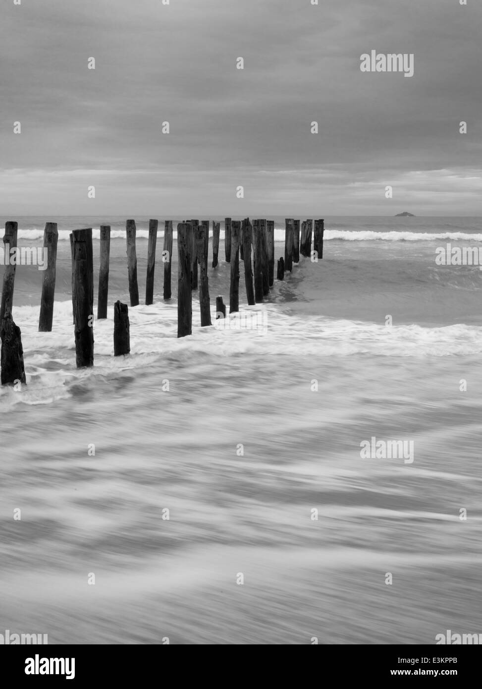 Blick auf die verlassenen Pier auf der St. Clair Strand, mit weißen Insel in der Ferne; Dunedin, Otago, Neuseeland Stockfoto