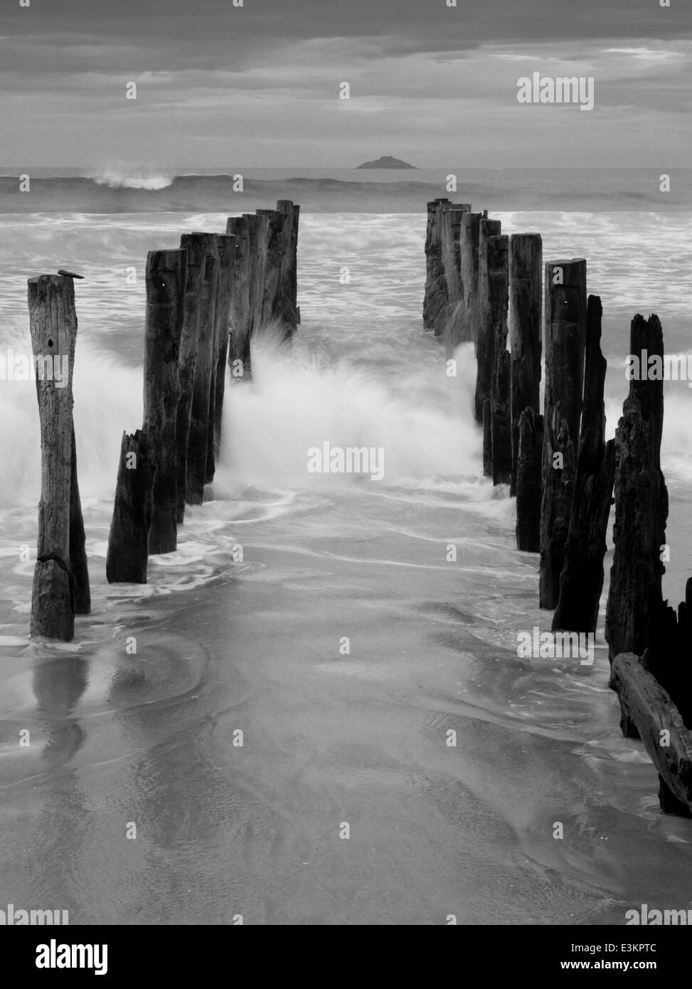 Blick auf die verlassenen Pier auf der St. Clair Strand, mit weißen Insel in der Ferne; Dunedin, Otago, Neuseeland Stockfoto