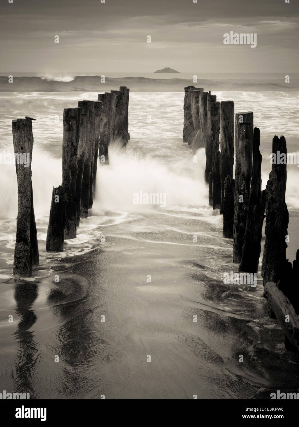 Blick auf die verlassenen Pier auf der St. Clair Strand, mit weißen Insel in der Ferne; Dunedin, Otago, Neuseeland Stockfoto