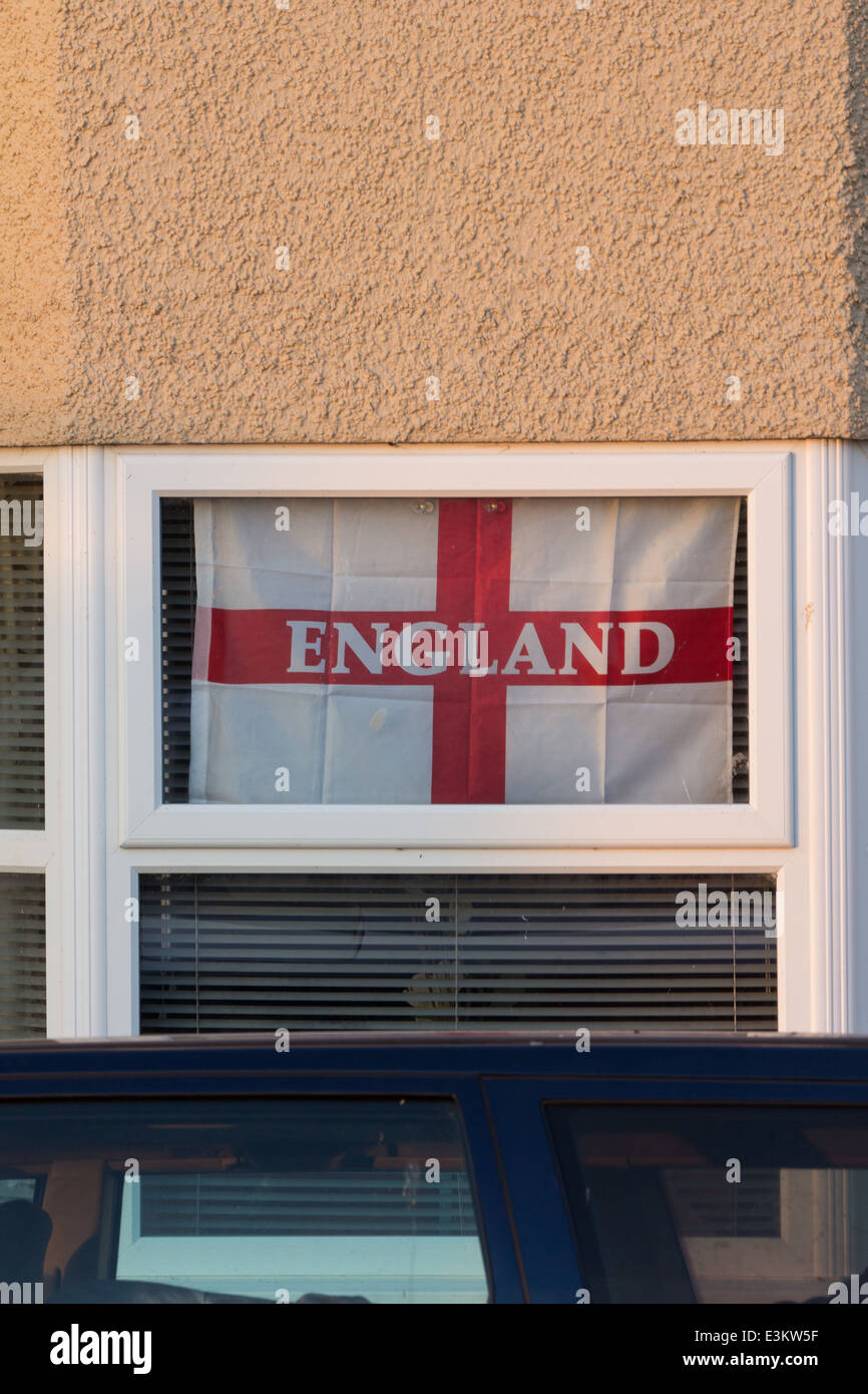 Ein einzelnes England Fußball Fan Flagge hängt Folornly im Fenster ein Meereshaus am Borth, Wales. Stockfoto