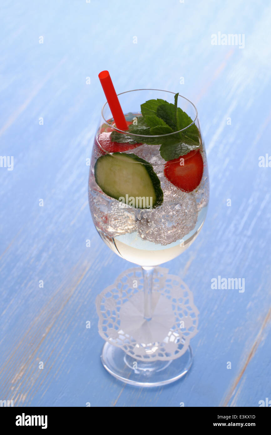 Cocktail mit Gurke, Erdbeere im Weinglas, Stroh und Deko Stockfoto