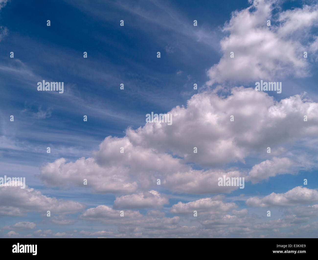 Weißen Cumulus-Wolken gegen den tiefblauen Himmel mit wispy hohe Niveau Cirruswolken Stockfoto