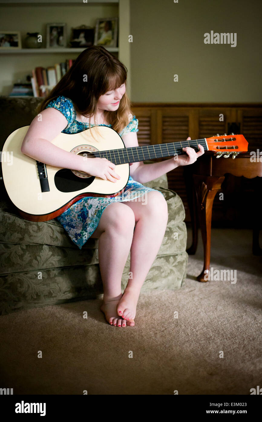 Bild von Teenager-Mädchen (13-15) spielt akustische Gitarre zu Hause Stockfoto