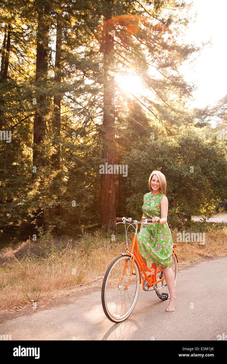 Frau mit ihrem Fahrrad auf der Landstraße Stockfoto