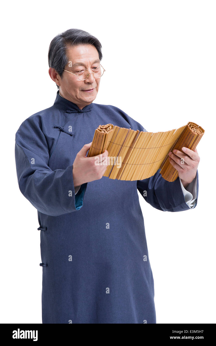 Oberlehrer in traditioneller Kleidung Lesung Bambus rutscht Stockfoto
