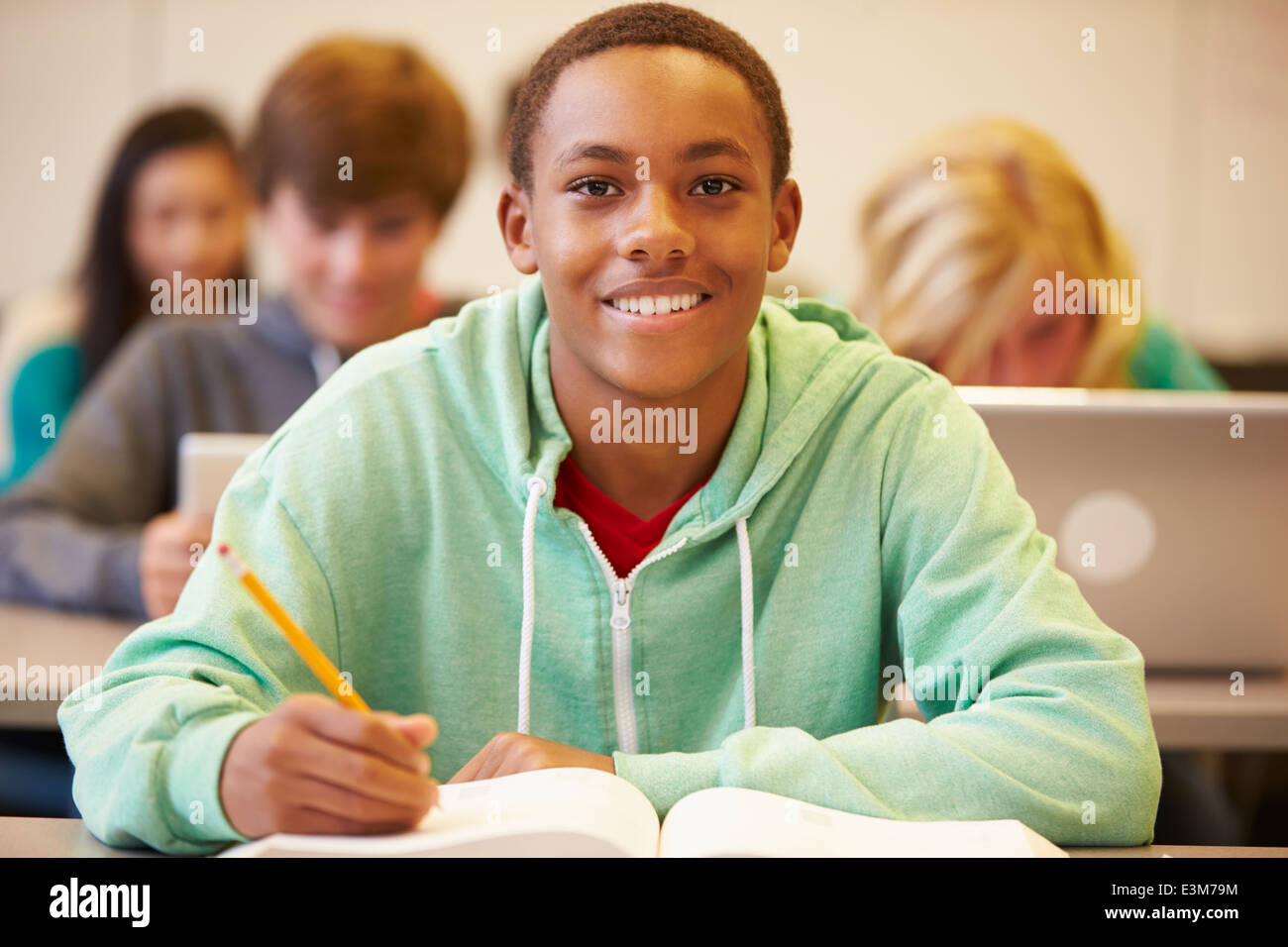 Männlichen High-School-Schüler studieren am Schreibtisch im Klassenzimmer Stockfoto