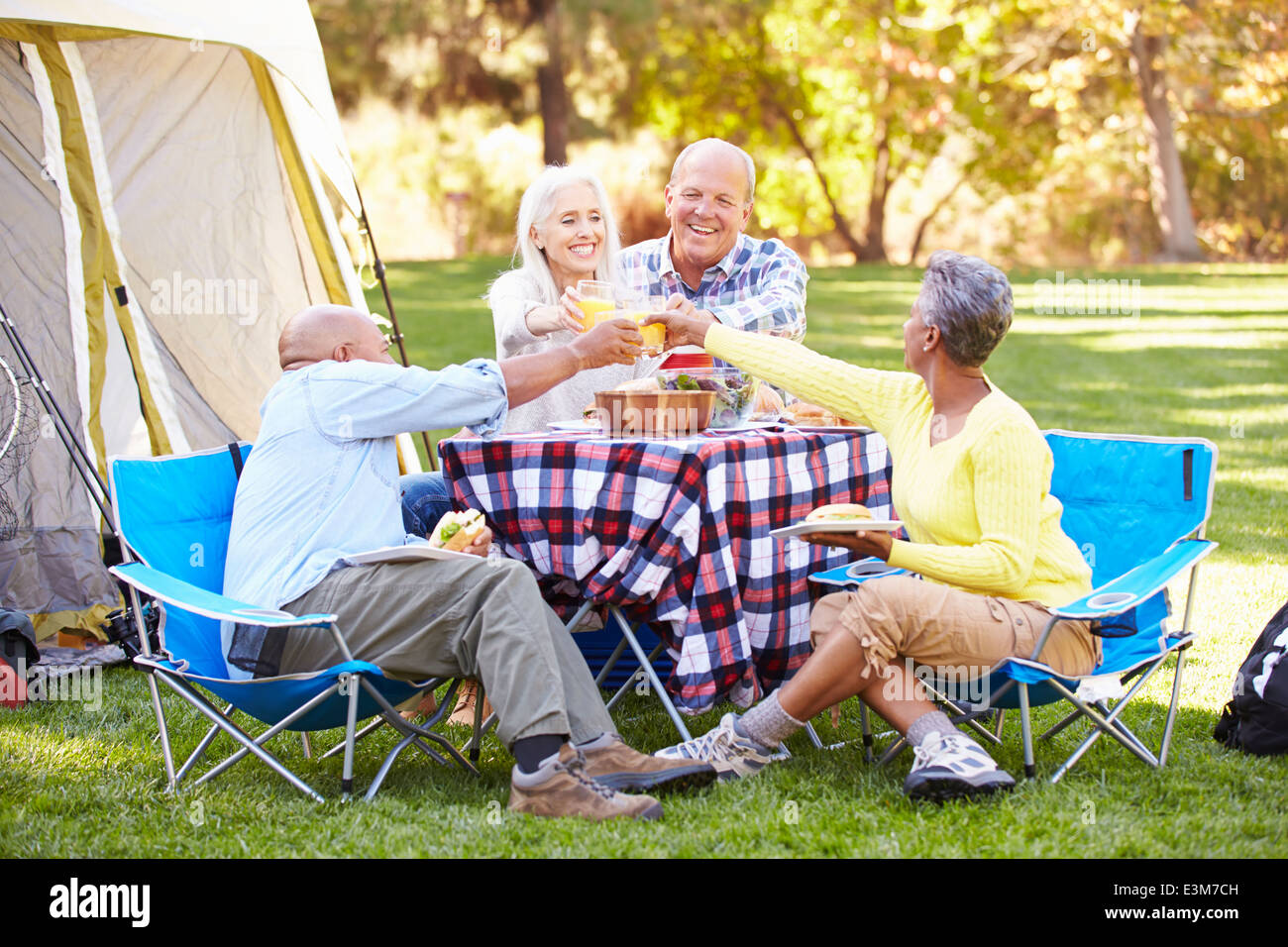 Zwei ältere Ehepaare genießen Camping-Urlaub In Natur Stockfoto