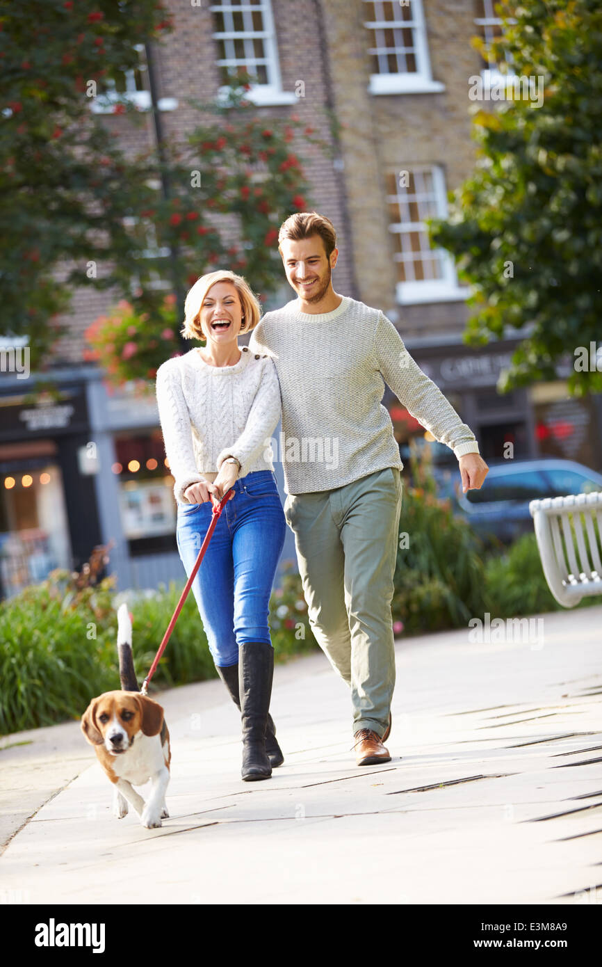 Paar mit Hund Spaziergang im Stadtpark Stockfoto