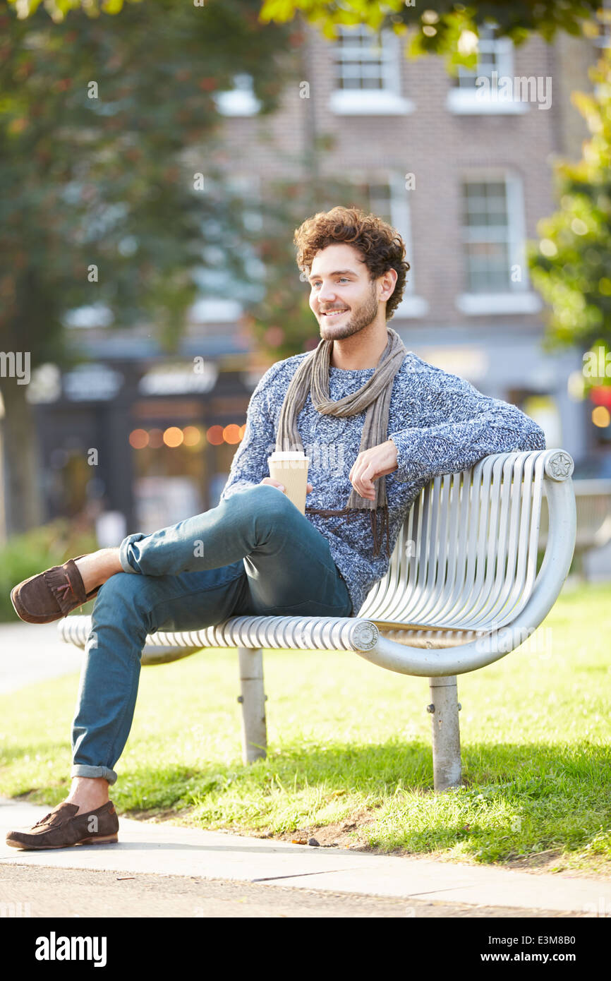 Mann auf der Parkbank mit Kaffee zum mitnehmen Stockfoto
