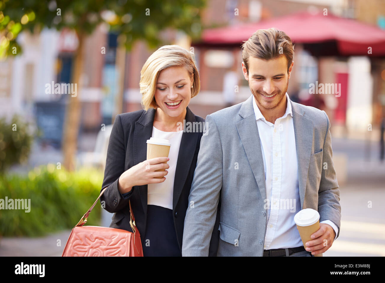 Business-paar zu Fuß durch den Park mit Kaffee zum mitnehmen Stockfoto
