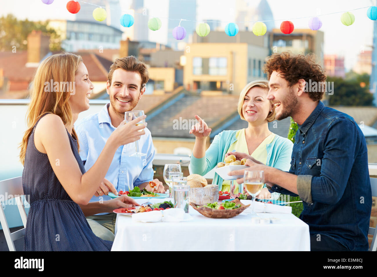 Gruppe von Freunden Essen auf Dachterrasse Stockfoto