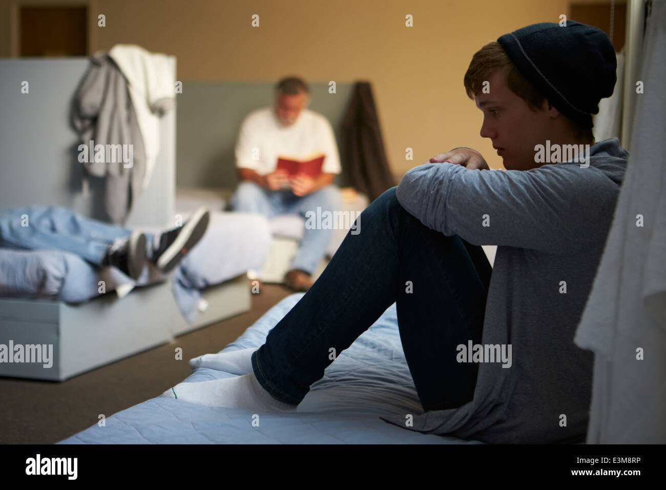 Männer liegen auf den Betten im Obdachlosenheim Stockfoto