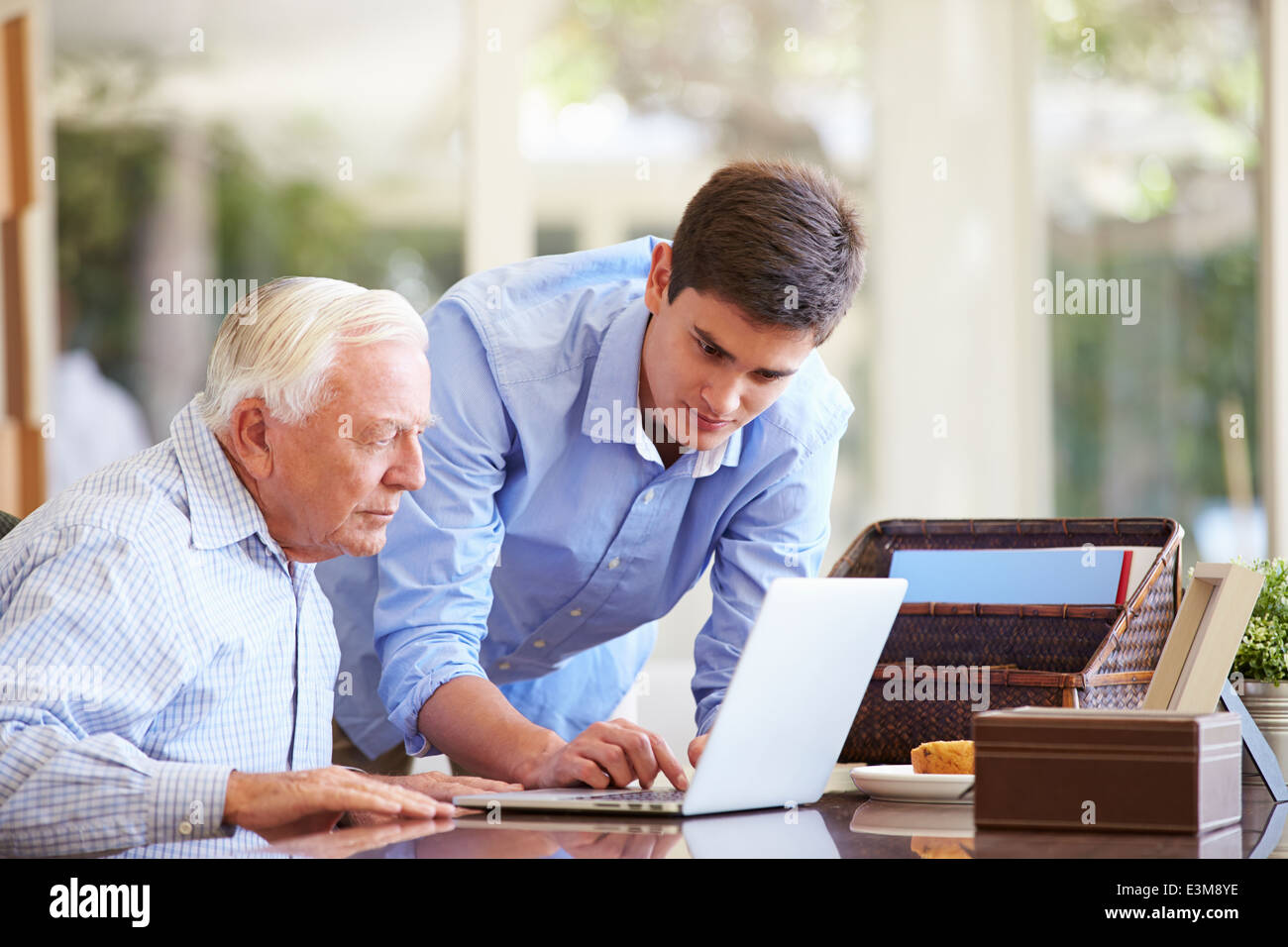 Teenager Enkel helfen Großvater mit Laptop Stockfoto