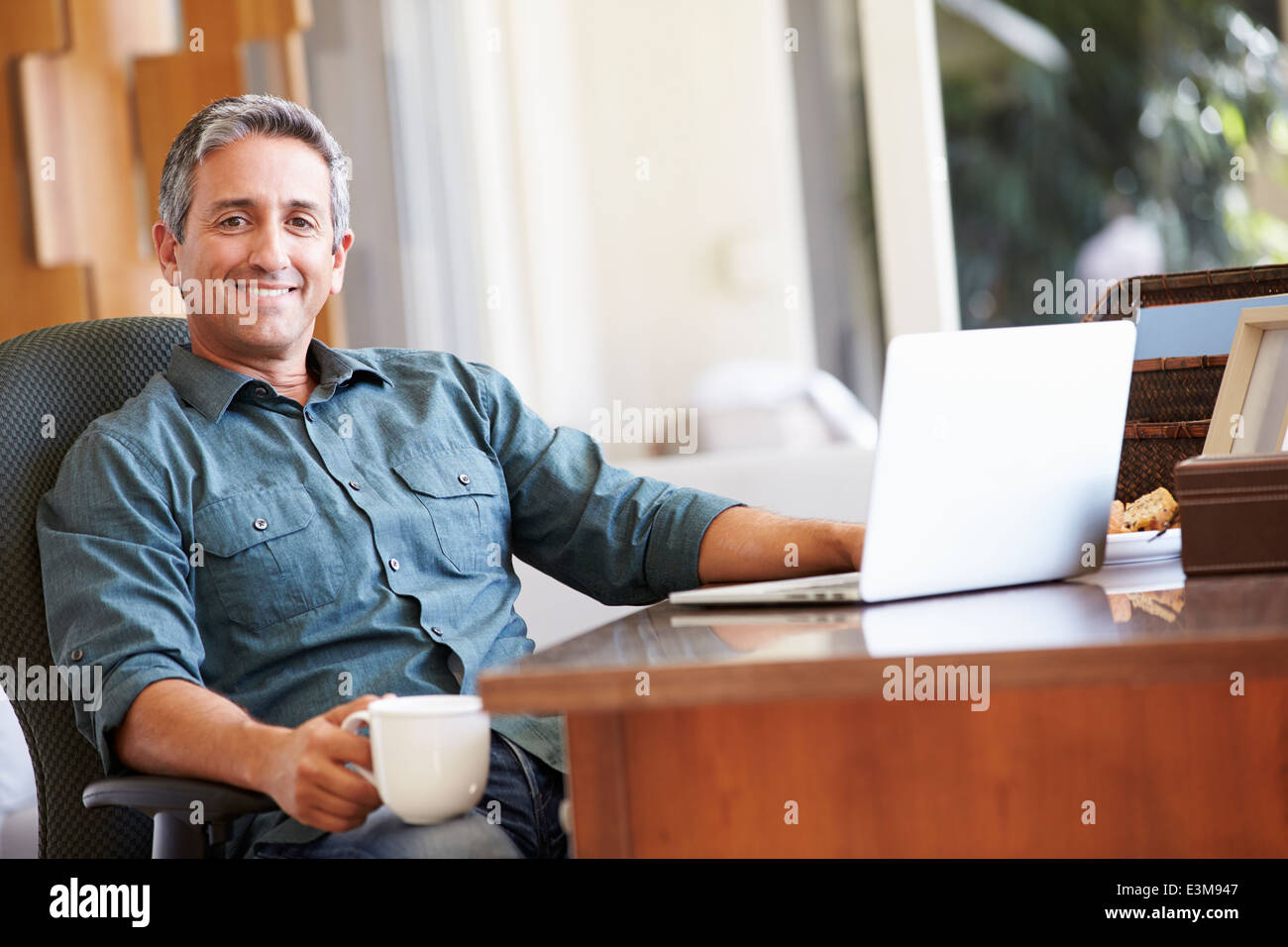Reifen Sie Hispanic Mann mit Laptop am Schreibtisch zu Hause Stockfoto