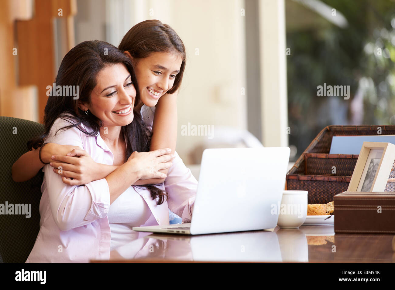Mutter und Tochter im Teenageralter auf Laptop zusammen Stockfoto