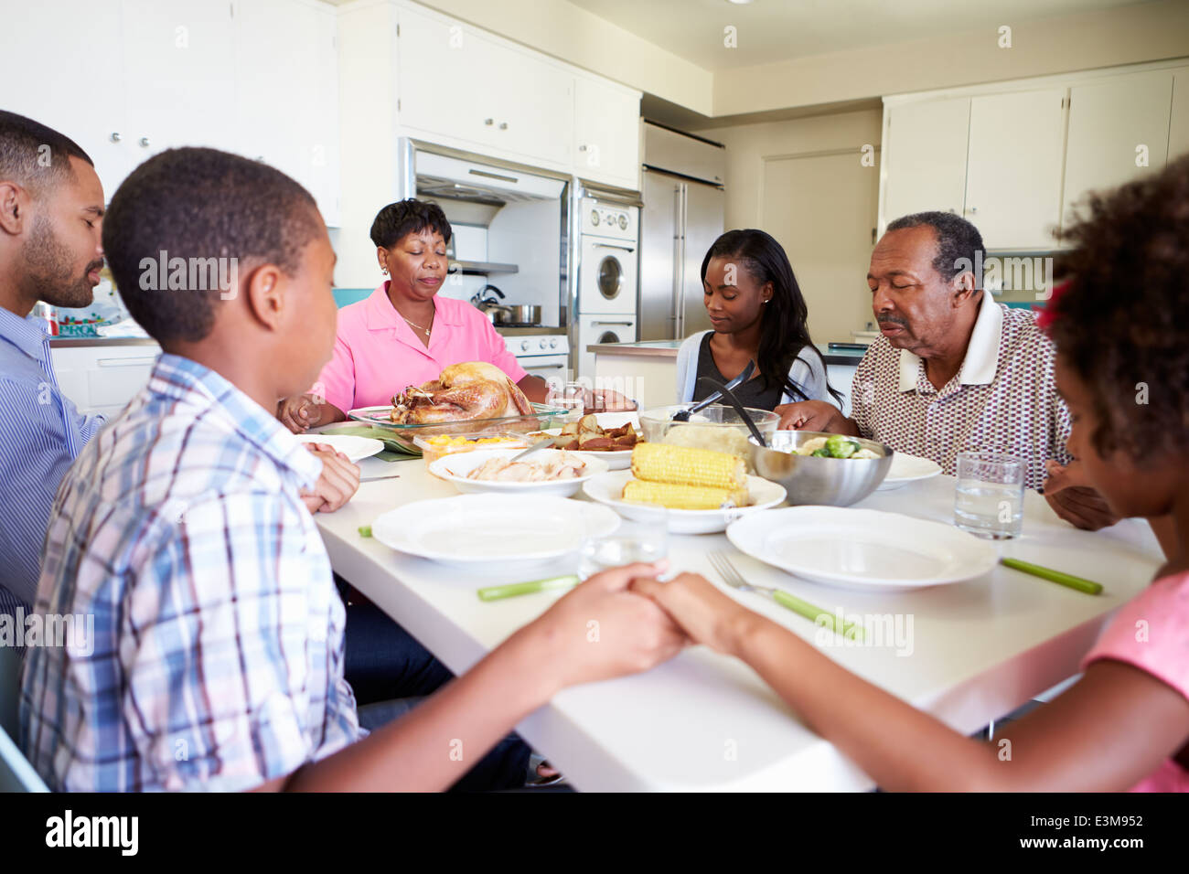 Mehr-Generationen-Familie Gebet vor dem Essen Stockfoto