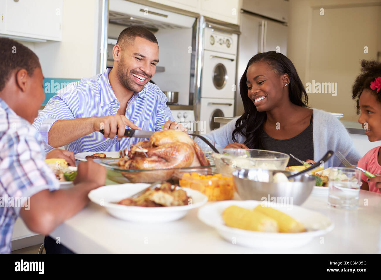 Familie sitzt an Tisch zu Hause essen Essen Stockfoto