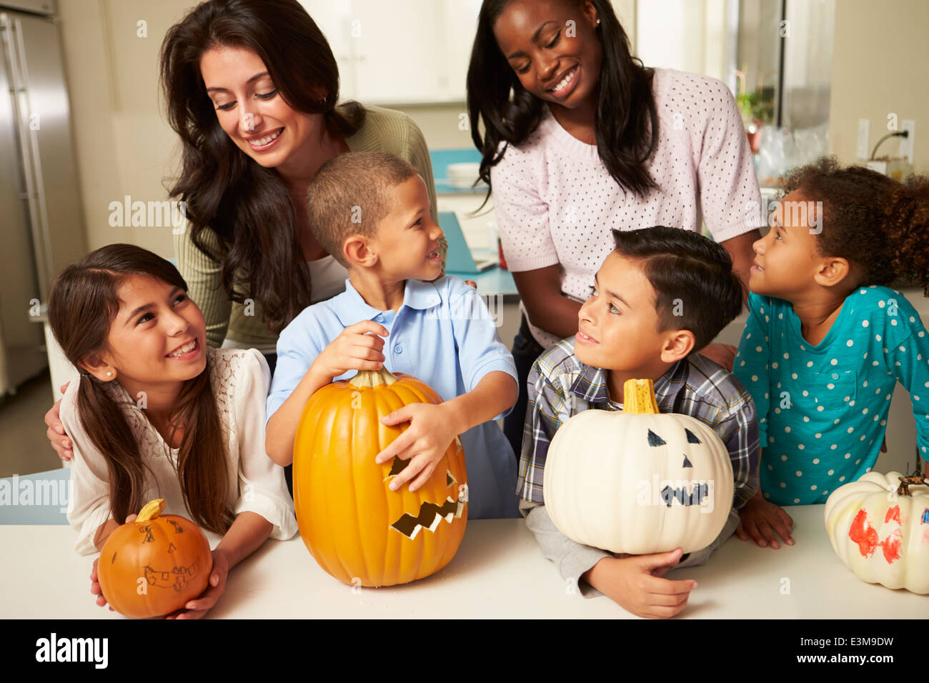Mütter und Kinder machen Halloween-Laternen Stockfoto