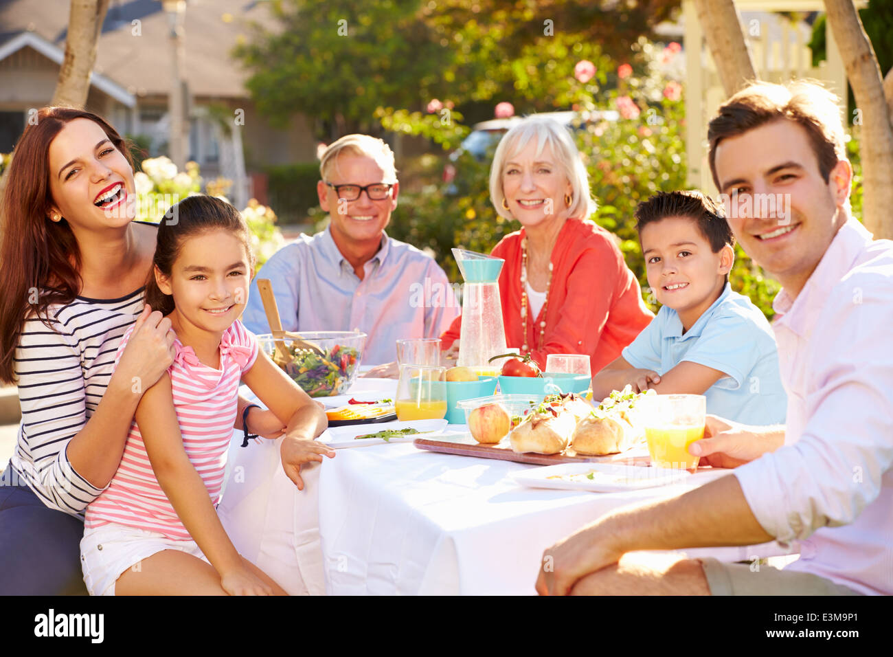 Mehr-Generationen-Familie Mahlzeit im Freien im Garten genießen Stockfoto