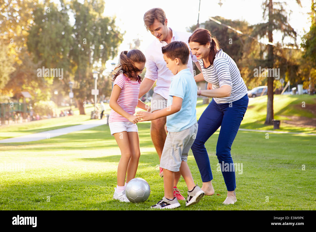 Familie zusammen spielen Fußball im Park Stockfoto