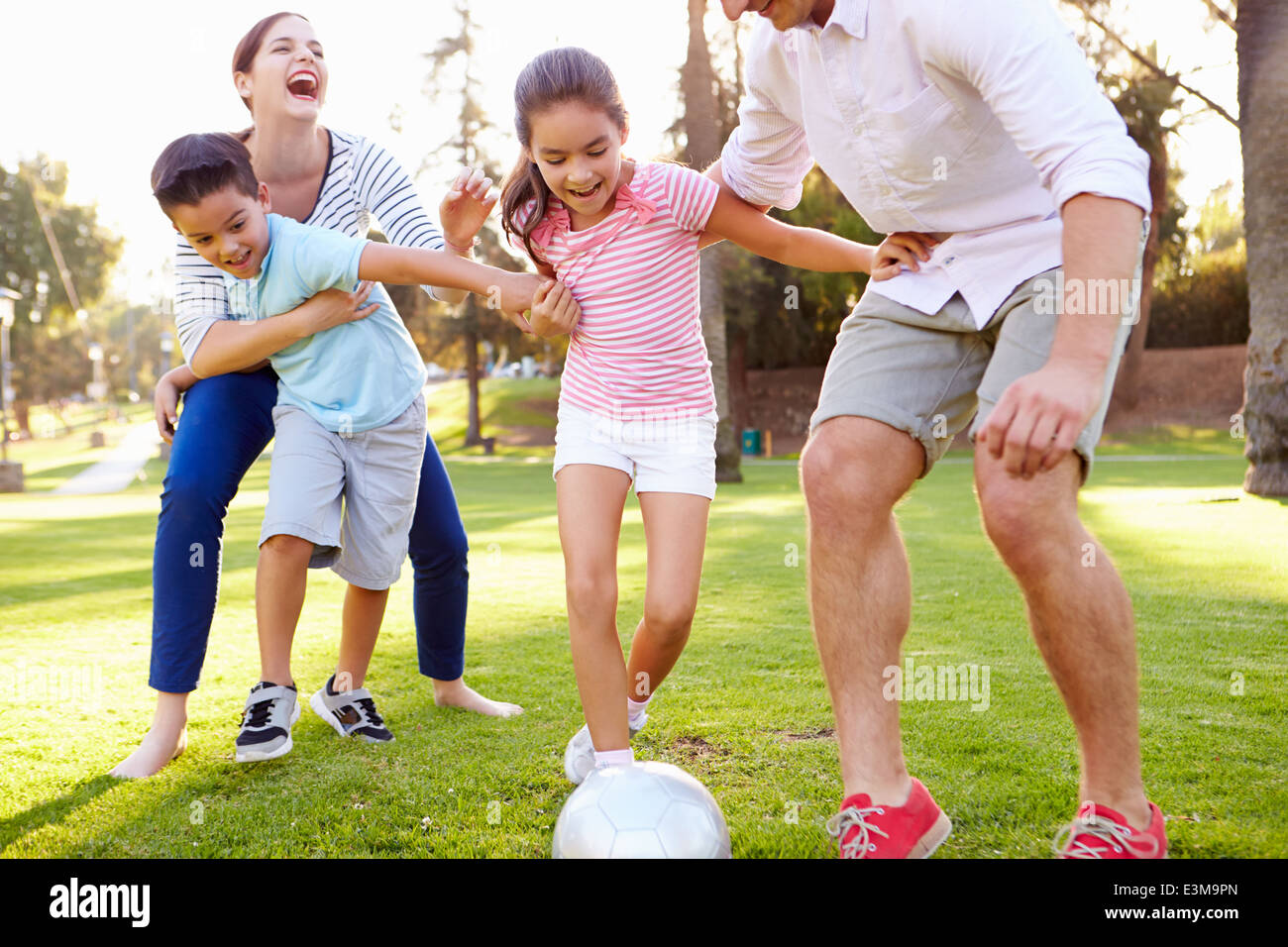 Familie zusammen spielen Fußball im Park Stockfoto