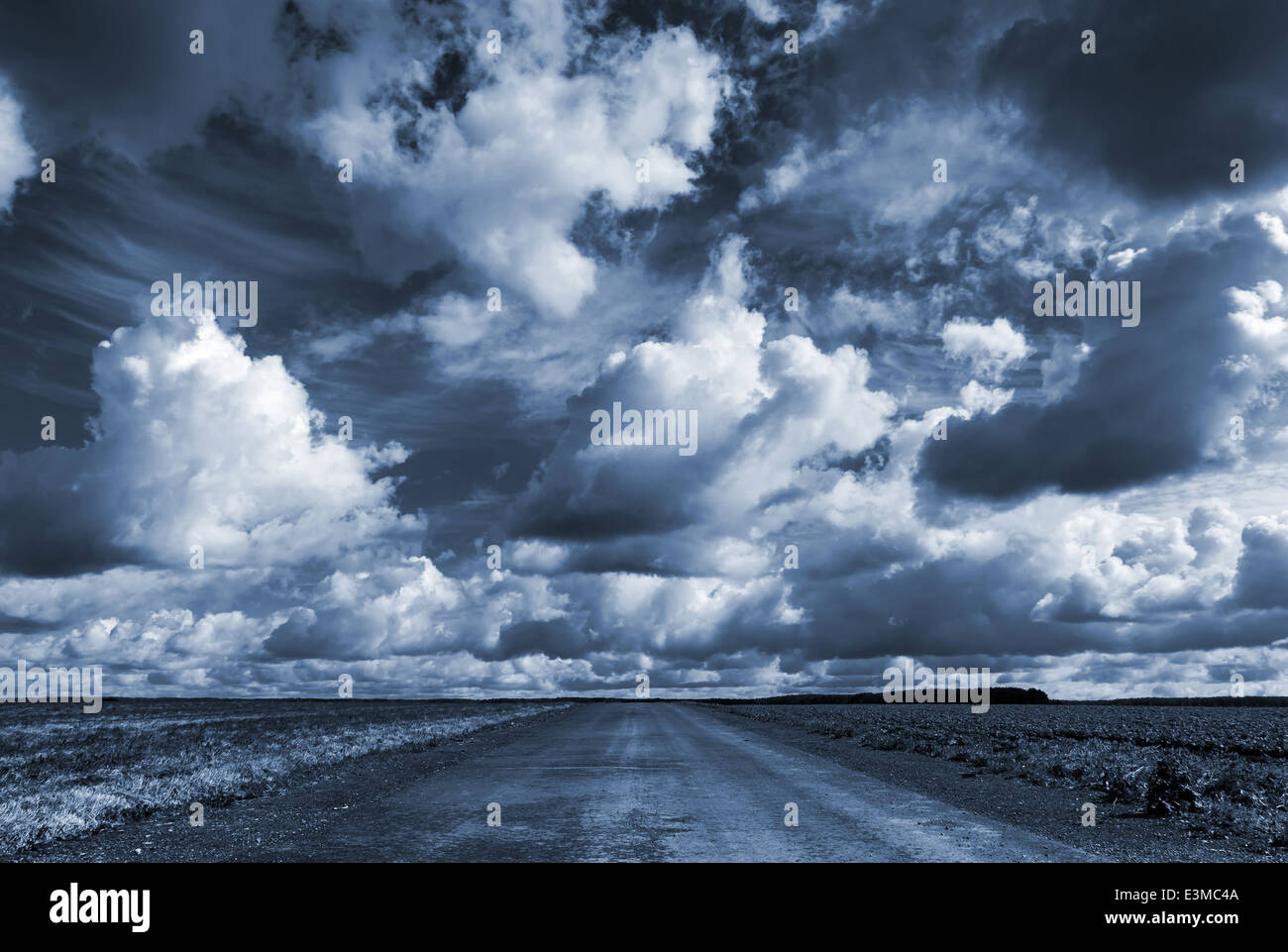 Leere Asphalt Landstraße unter dunklen dramatischen Wolkenhimmel Stockfoto