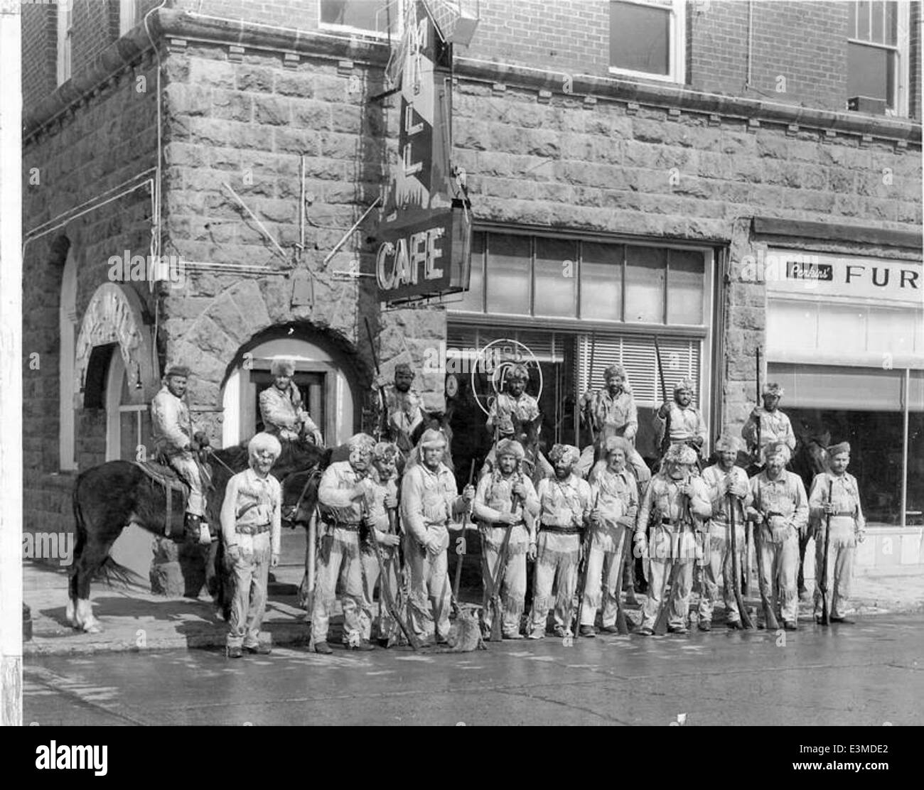 Historisches Foto mit einer Gruppe von Männern vor dem Mills Café in Williams, Arizona, das ein beliebter Zwischenstopp für Reisende entlang der Route 66 war. Das Foto zeigt eine Momentaufnahme der amerikanischen Geschichte Mitte des 20. Jahrhunderts. Stockfoto