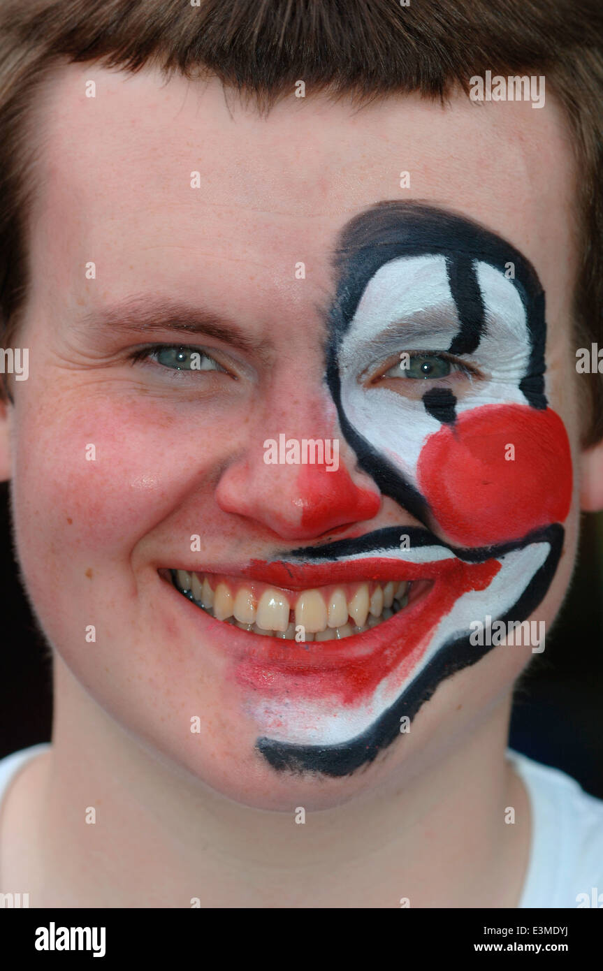 Teenager mit Hälfte seines Gesichts gemalt als Clown. Stockfoto