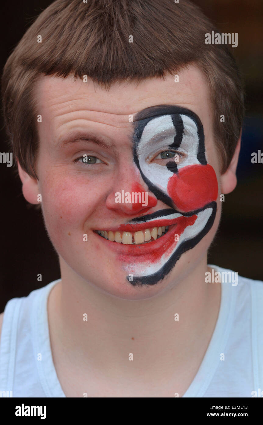 Teenager mit Hälfte seines Gesichts gemalt als Clown. Stockfoto