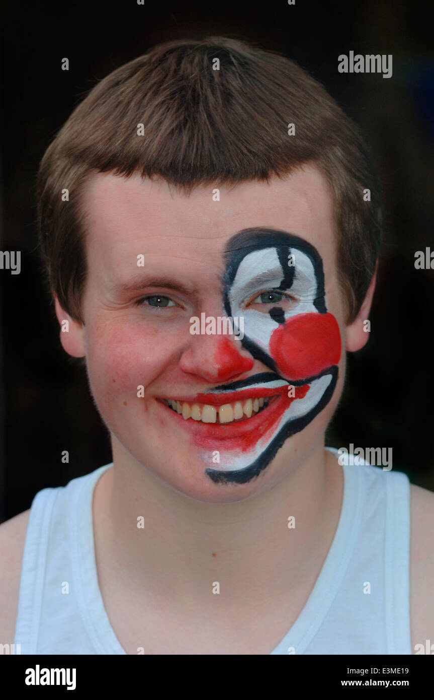 Teenager mit Hälfte seines Gesichts gemalt als Clown. Stockfoto