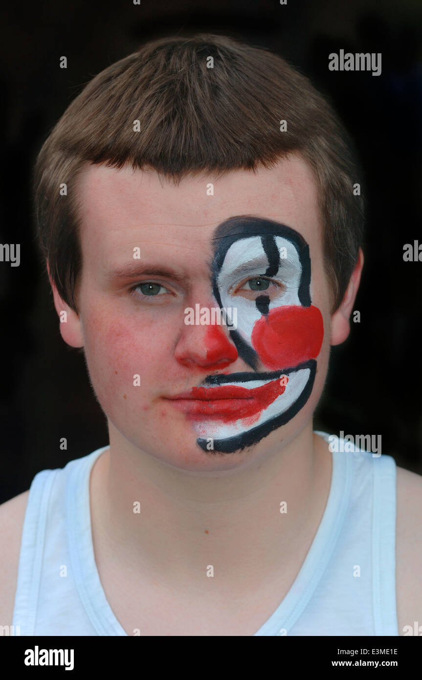 Teenager mit Hälfte seines Gesichts gemalt als Clown. Stockfoto