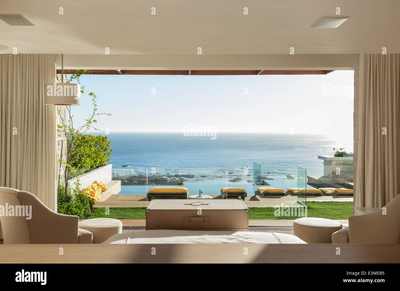 Sonniges Schlafzimmer und Terrasse mit Blick auf Meer Stockfoto