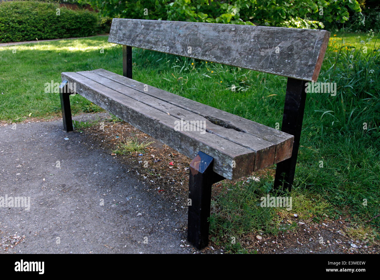 Hölzerne Parkbank inmitten von Grünland Stockfoto