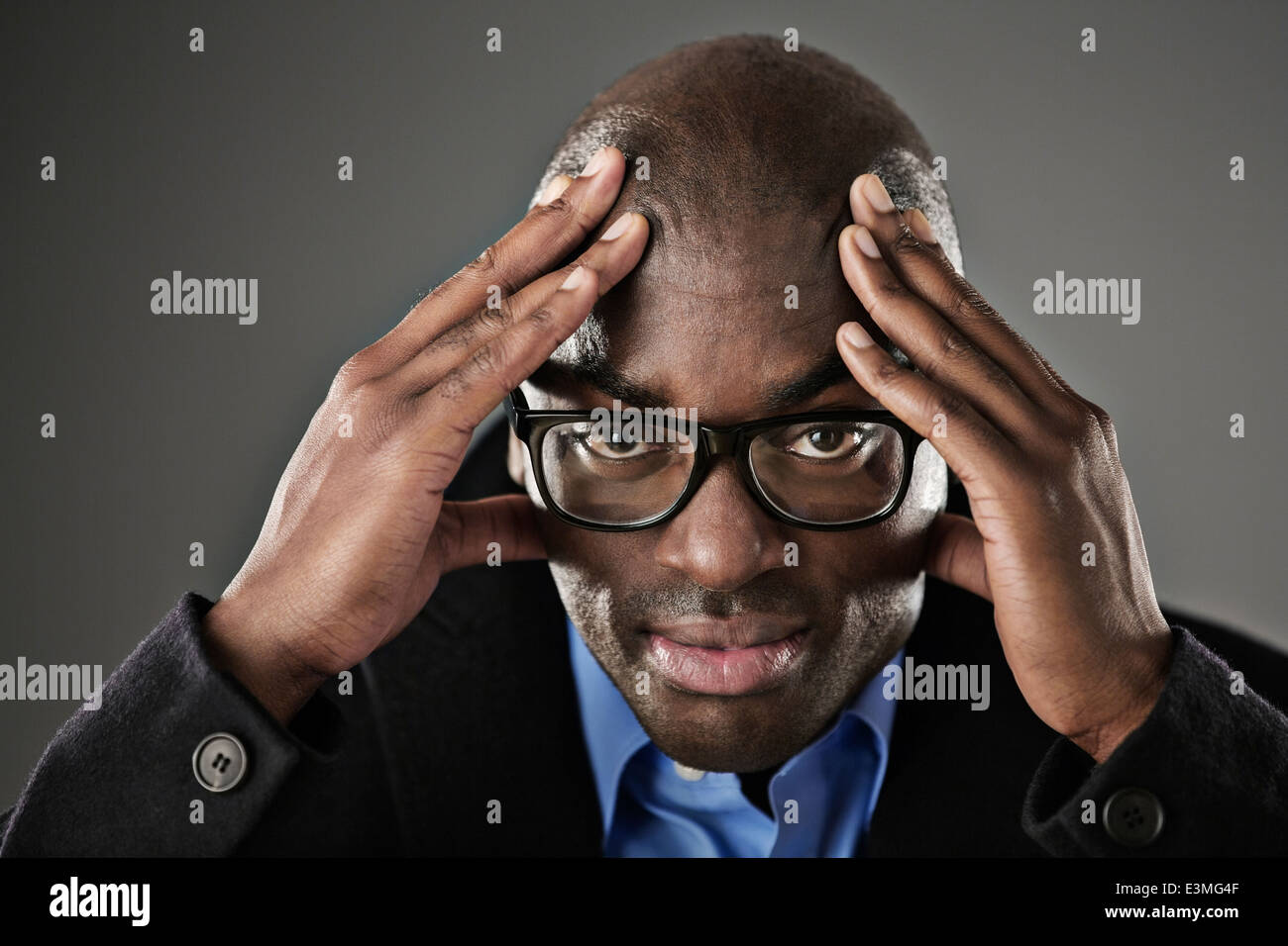 Porträt von gestressten Geschäftsmann mit Kopf in Händen Stockfoto