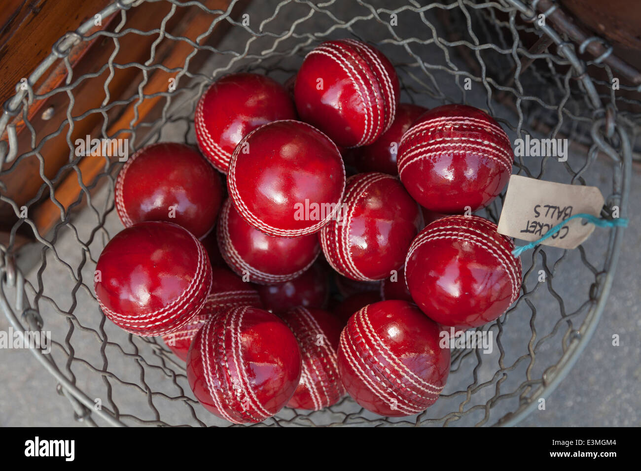 Nahaufnahme eines glänzenden roten Real-Leder Cricket Kugeln in einen Drahtkorb Stockfoto